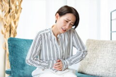お腹を押さえる女性