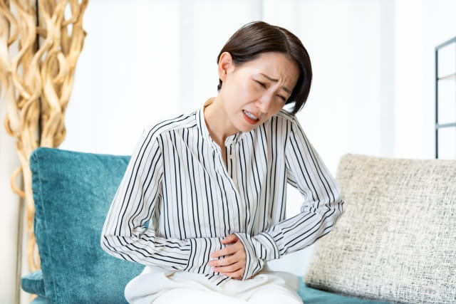 お腹を押さえる女性